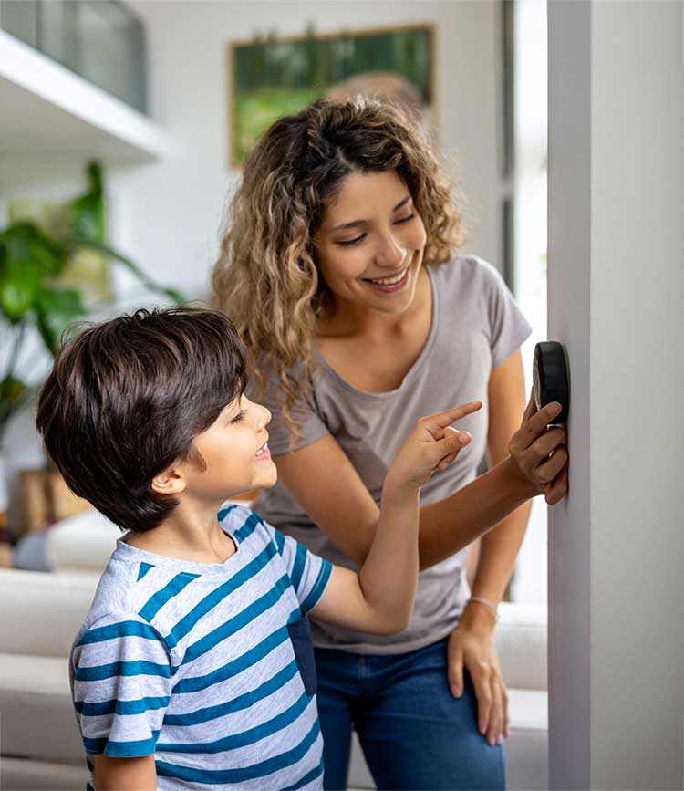 Mother and child explore smart thermostat settings